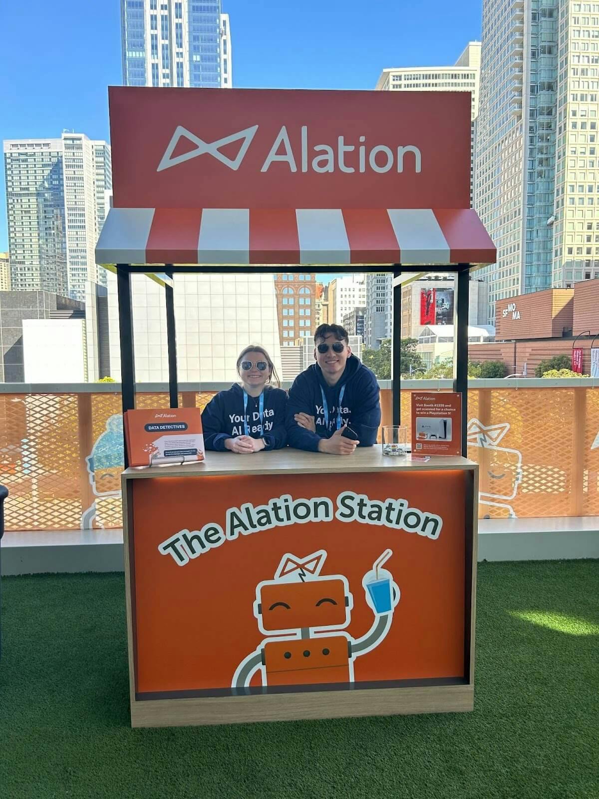 Two Alationauts serving smoothies at the Alation Station at Snowflake Summit 2024.
